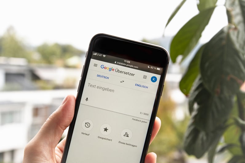 Hand holding phone showing Google Translate