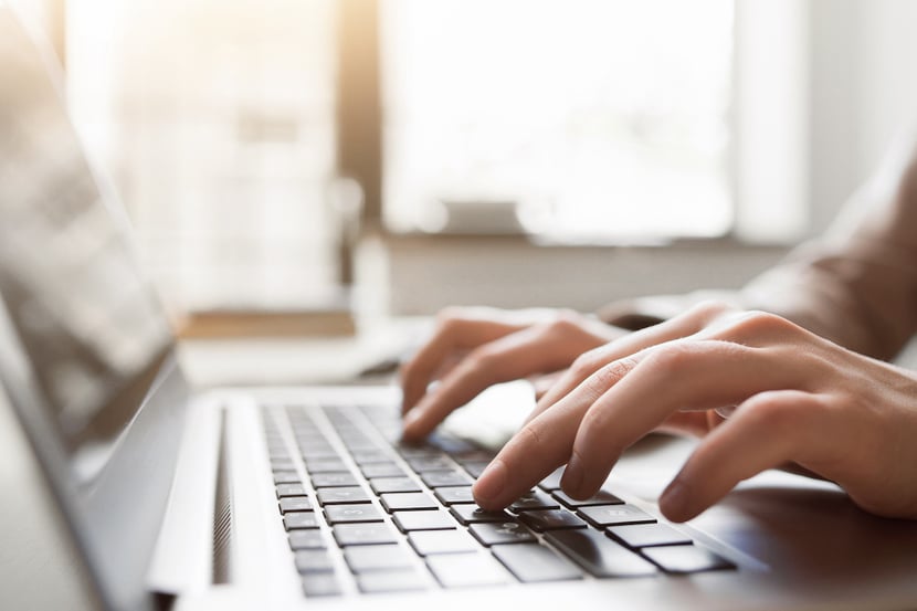 Fingers typing on a computer